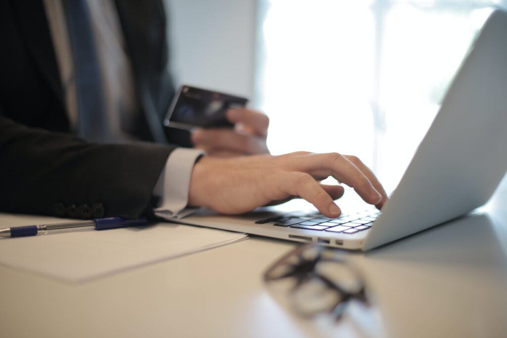 Personne qui rempli un formulaire en ligne avec les cordonnées de la carte qu'il tient en main.